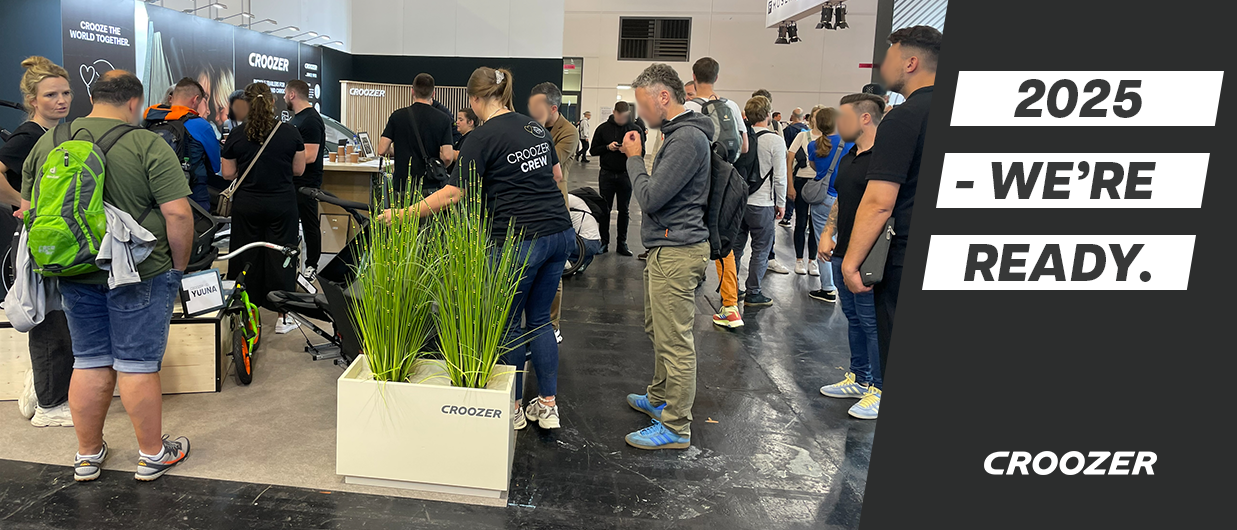 Visitors at the Croozer trade fair booth 2024, presenting new products like the Croozer Kid Yuuna, slogan ‚2025 – We’re ready.‘
